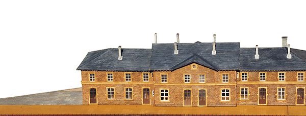 Kit GARE D'ETTELBRUCK : ce Kit représente la gare telle qu'elle était en 1926, à trois corps rattachés, sans toilettes latérales et avec des cheminées en maçonnerie.
Les fenêtres du rez-de-chaussée avaient déjà été modifiées mais portent la marque d'une arcature ancienne.
Ce Kit comprend les parquets et planchers intérieurs gravés et les cloisons avec ouvrants complèts. La toiture est en plaques d'ardoises rectangulaires en carton fort livrées en bandes avec ligne de positionnement.
L'empierrement fait l'objet d'une fine gravure en relief qui rend parfaitement l'aspect des pierres originales.
La marquise est livrée option avec le socle, référence 360-18.